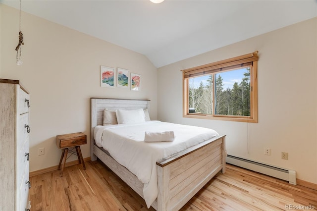 1002 County Road 99, Black Hawk, CO 80422 - bedroom with a baseboard heating unit, vaulted ceiling, light wood-style flooring, and baseboards