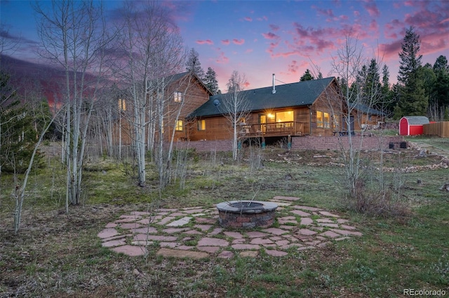 1002 County Road 99, Black Hawk, CO 80422 - back of property at dusk with a fire pit and a wooden deck