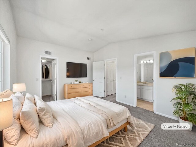 6850 Xavier Cir Unit 12, Westminster, CO 80030 - bedroom featuring vaulted ceiling, carpet flooring, baseboards, connected bathroom, and a spacious closet