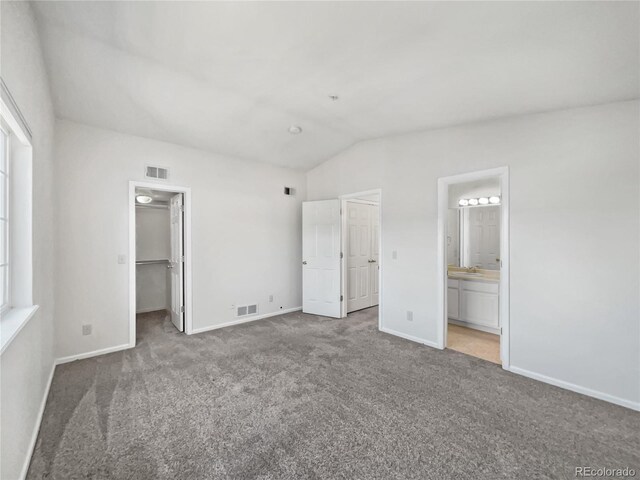 6850 Xavier Cir Unit 12, Westminster, CO 80030 - unfurnished bedroom with carpet flooring, lofted ceiling, baseboards, a walk in closet, and multiple windows
