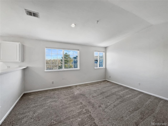 carpeted spare room with lofted ceiling