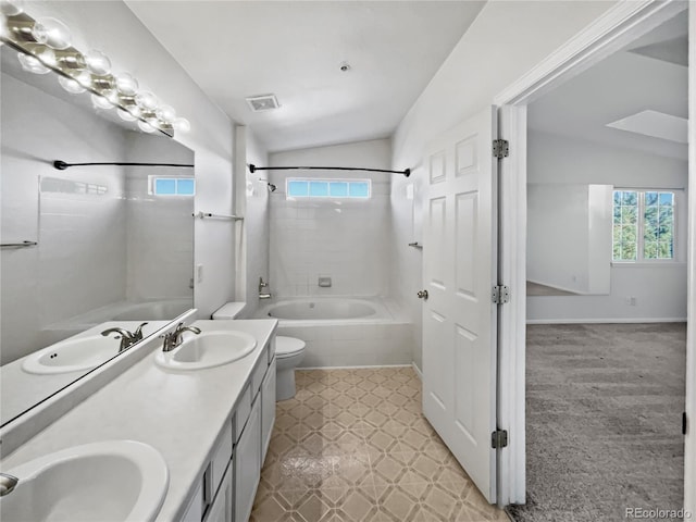 full bathroom featuring vanity, tiled shower / bath combo, vaulted ceiling, and toilet