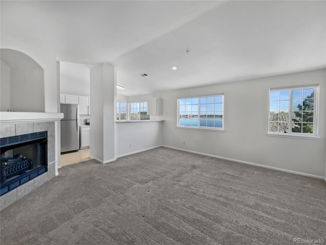 unfurnished living room with a fireplace and light colored carpet