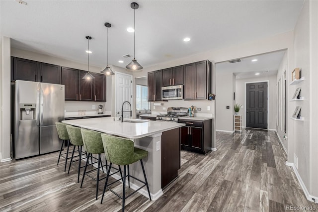 10595 Boston St, Commerce City, CO 80640 - kitchen with appliances with stainless steel finishes, a sink, dark brown cabinetry, dark wood-style flooring, and recessed lighting