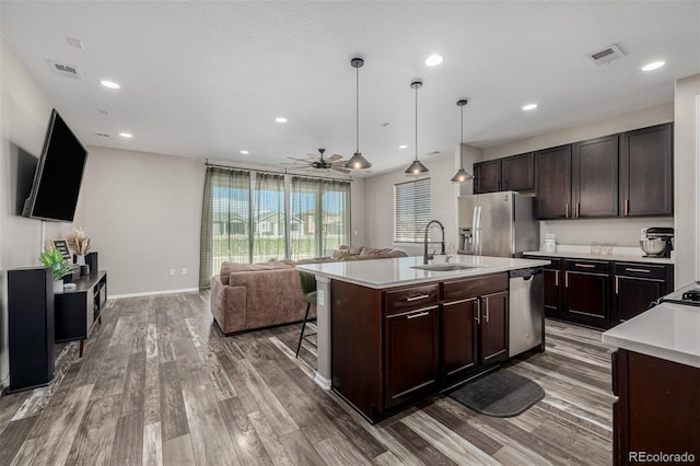 10595 Boston St, Commerce City, CO 80640 - kitchen featuring appliances with stainless steel finishes, a sink, light countertops, wood finished floors, and recessed lighting