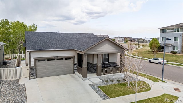 10595 Boston St, Commerce City, CO 80640 - view of front of property with covered porch, stone siding, an attached garage, and driveway