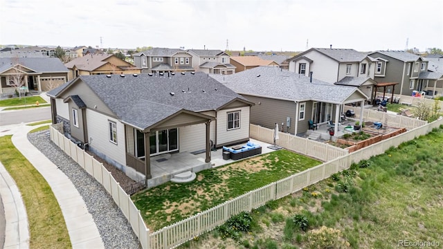 10595 Boston St, Commerce City, CO 80640 - back of house with a residential view, a patio area, roof with shingles, and an outdoor living space
