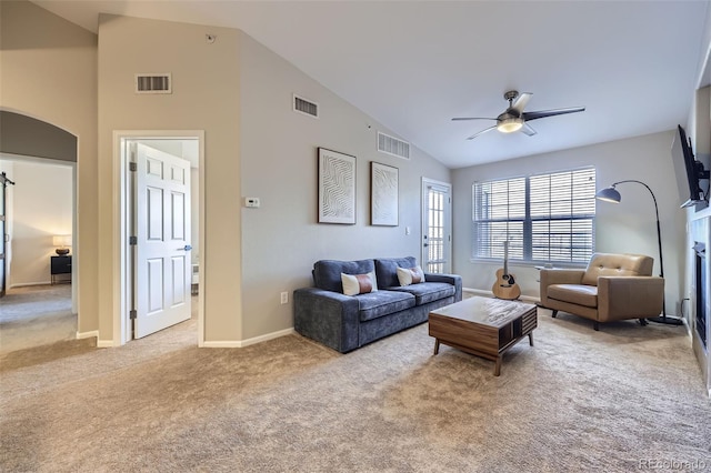 carpeted living room with a fireplace, high vaulted ceiling, and ceiling fan