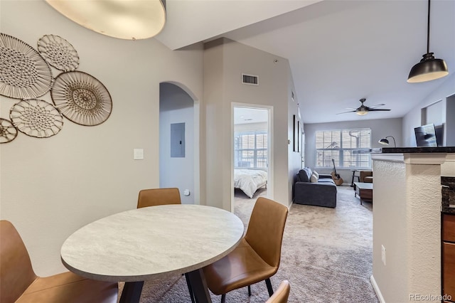 carpeted dining room featuring ceiling fan and electric panel