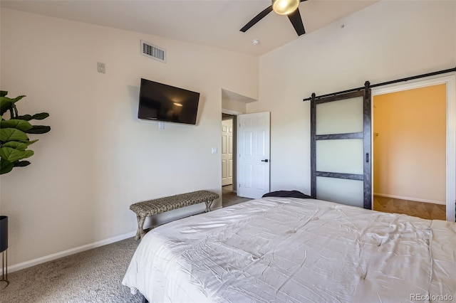 carpeted bedroom featuring ceiling fan, a barn door, and vaulted ceiling