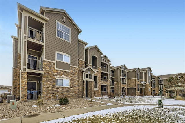 snow covered property with central AC