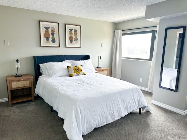 bedroom with a textured ceiling and dark colored carpet