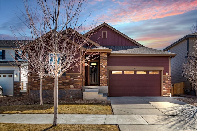 view of front of home with board and batten siding, concrete driveway, a shingled roof, and a garage