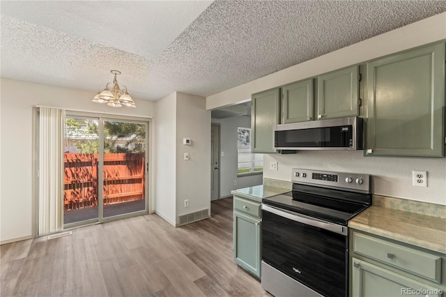 1344 Firefly Cir, Colorado Springs, CO 80916 - kitchen featuring green cabinetry, appliances with stainless steel finishes, a textured ceiling, a chandelier, and healthy amount of natural light