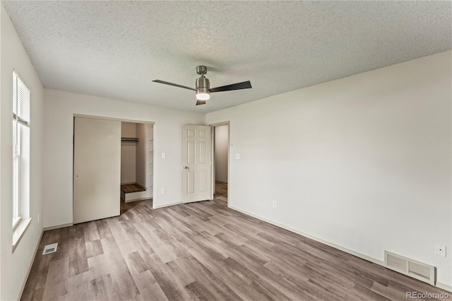 1344 Firefly Cir, Colorado Springs, CO 80916 - unfurnished bedroom with wood finished floors, a textured ceiling, a ceiling fan, and a closet