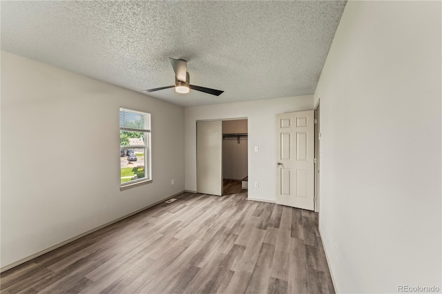 1344 Firefly Cir, Colorado Springs, CO 80916 - unfurnished bedroom featuring wood finished floors, a textured ceiling, a closet, and ceiling fan