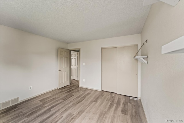 1344 Firefly Cir, Colorado Springs, CO 80916 - unfurnished bedroom with wood finished floors, a closet, and a textured ceiling