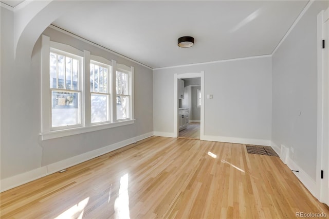 unfurnished room featuring ornamental molding and hardwood / wood-style flooring