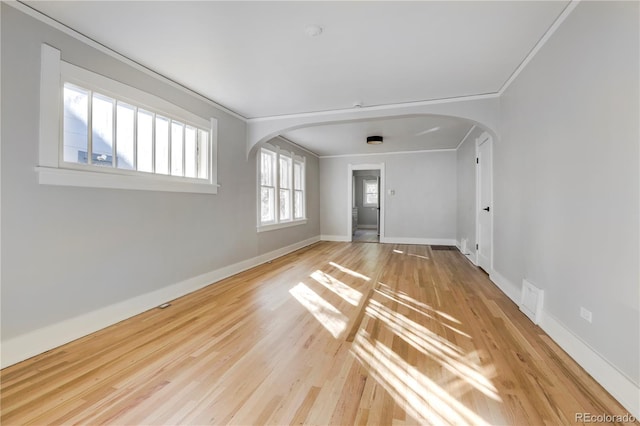 empty room featuring crown molding and light wood-type flooring