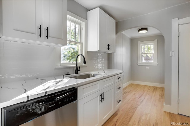 2103 S Lafayette St, Denver, CO 80210 - kitchen with dishwasher, light wood-style floors, white cabinets, light stone counters, and arched walkways