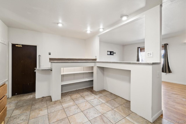 kitchen featuring light countertops, light tile patterned floors, and baseboards