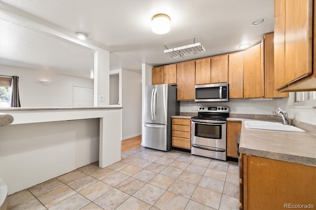 kitchen featuring a sink, stainless steel appliances, and light tile patterned flooring