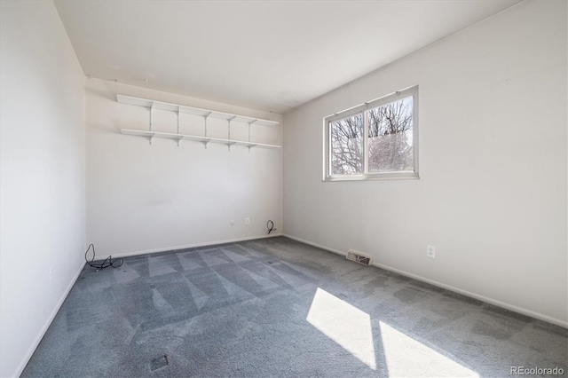 empty room featuring visible vents, baseboards, and carpet