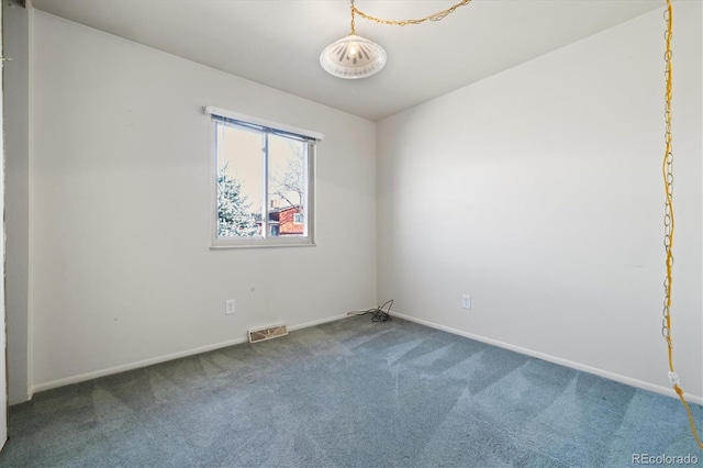 empty room featuring baseboards, visible vents, and carpet floors