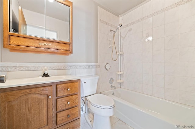 bathroom with tile walls, a wainscoted wall, toilet, shower / bathing tub combination, and vanity