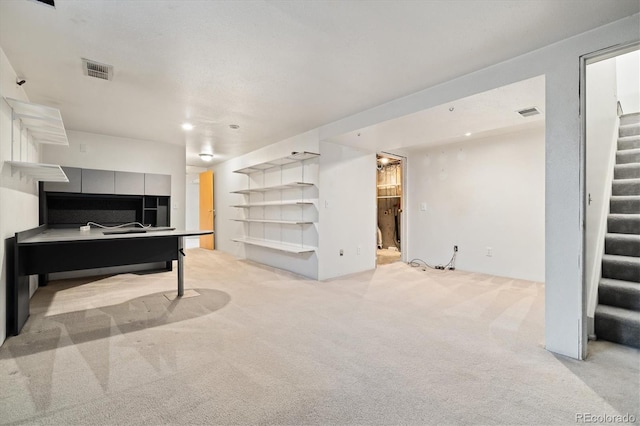 living area with stairway, visible vents, and light carpet