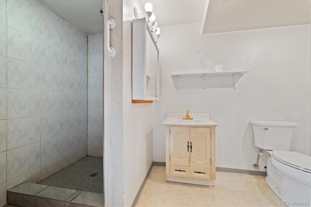 full bathroom featuring a tile shower, toilet, baseboards, and a sink