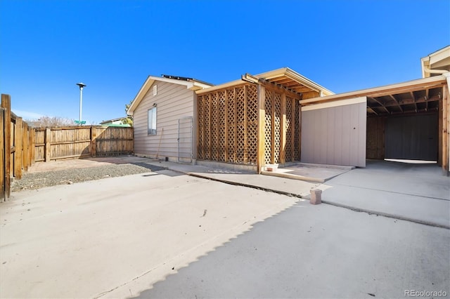 view of side of property featuring a carport and fence