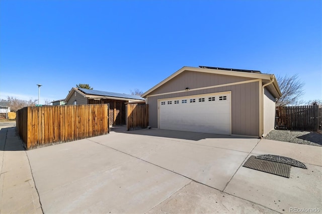 view of front of home featuring an outbuilding, driveway, a garage, and fence