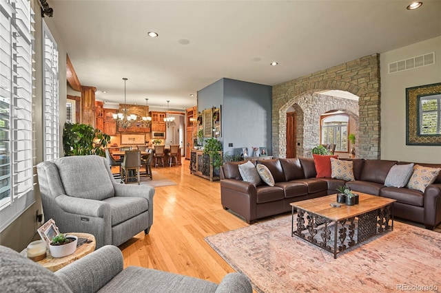 living room featuring light wood-type flooring and a notable chandelier