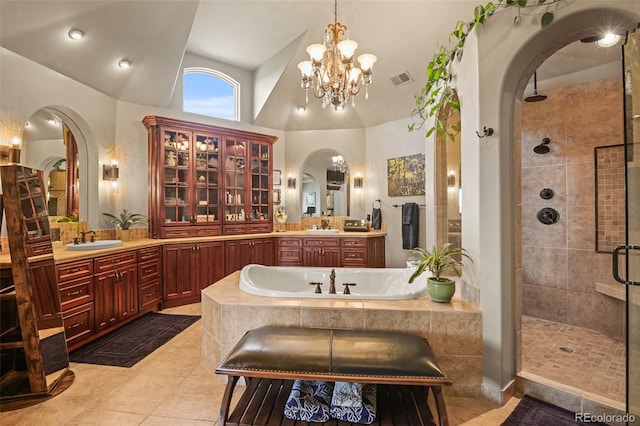 bathroom featuring tile patterned floors, lofted ceiling, independent shower and bath, and vanity