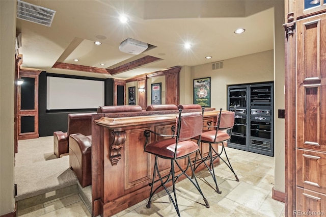 home theater with bar and a tray ceiling