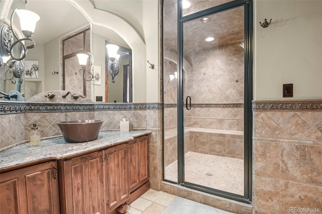 bathroom with vanity, tile walls, and an enclosed shower