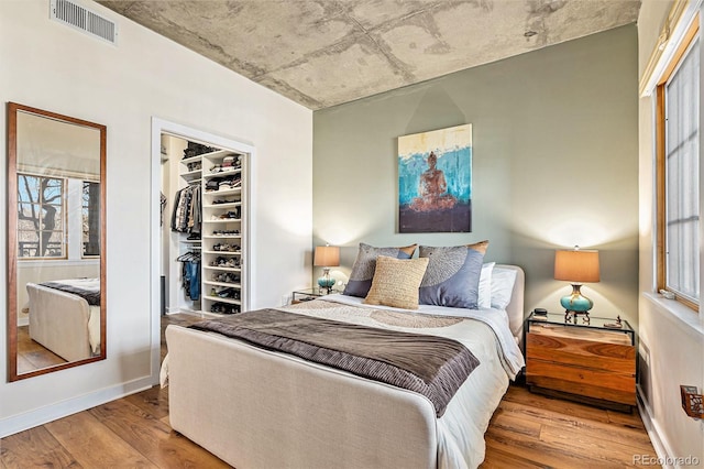 bedroom featuring multiple windows, wood-type flooring, and a closet