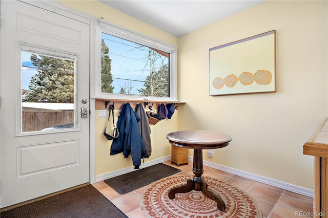 doorway to outside with baseboards and light tile patterned flooring