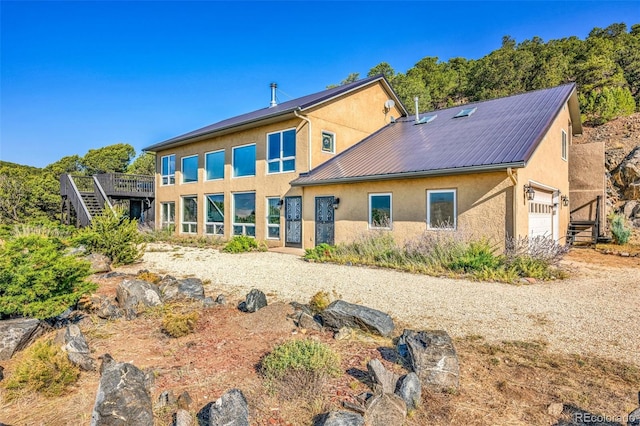 rear view of property with a garage and a deck