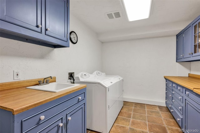 washroom featuring cabinets, tile patterned flooring, sink, and washing machine and clothes dryer