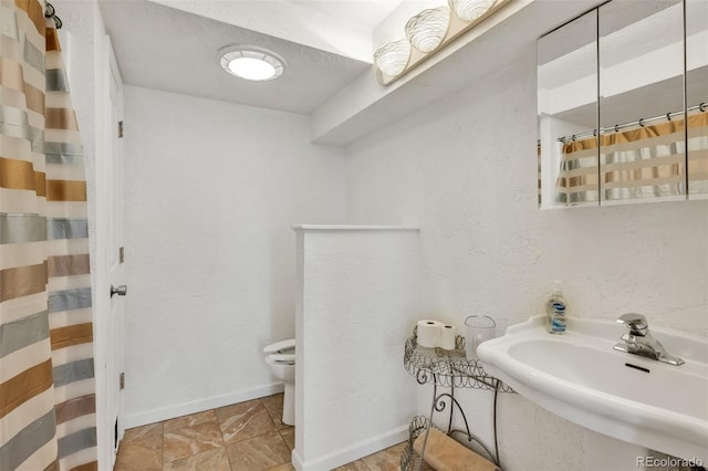 bathroom featuring sink, toilet, and a shower with shower curtain