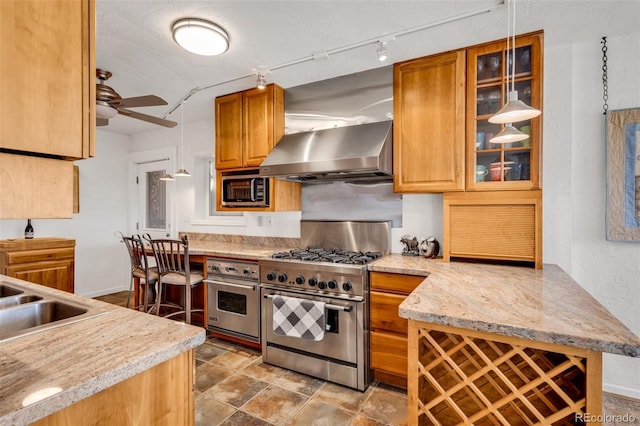 kitchen with light stone counters, ceiling fan, sink, ventilation hood, and appliances with stainless steel finishes