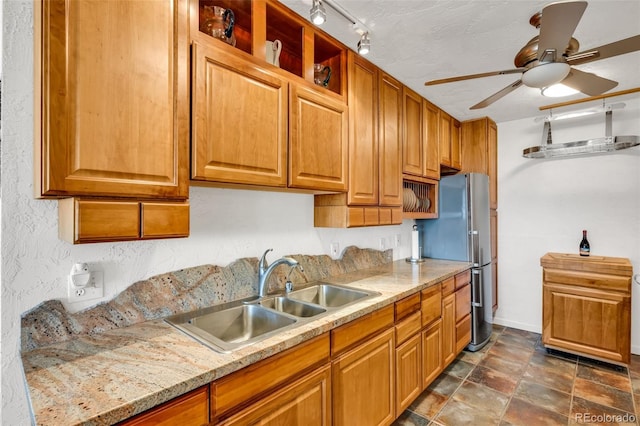 kitchen with stainless steel fridge, ceiling fan, sink, and a textured ceiling