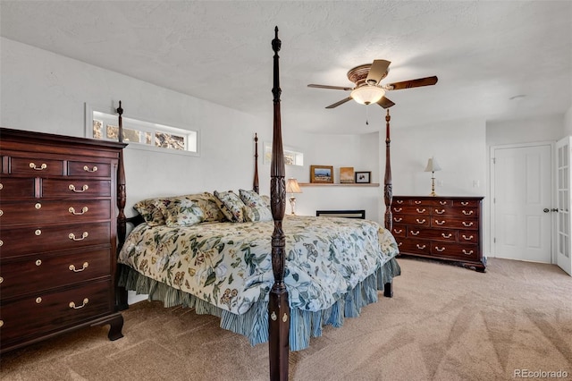 carpeted bedroom with ceiling fan and a textured ceiling