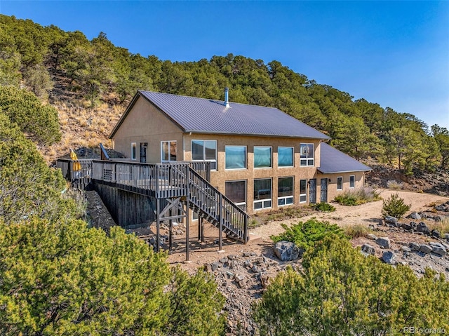 rear view of property featuring a wooden deck