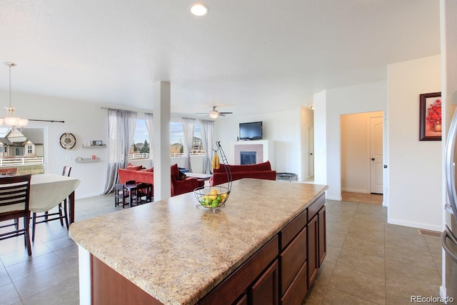 kitchen with a center island, pendant lighting, ceiling fan, and light tile patterned floors