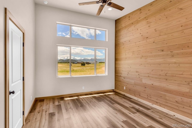 388 14th Trl, Cotopaxi, CO 81223 - unfurnished room featuring ceiling fan, plenty of natural light, baseboards, wooden walls, and wood finished floors