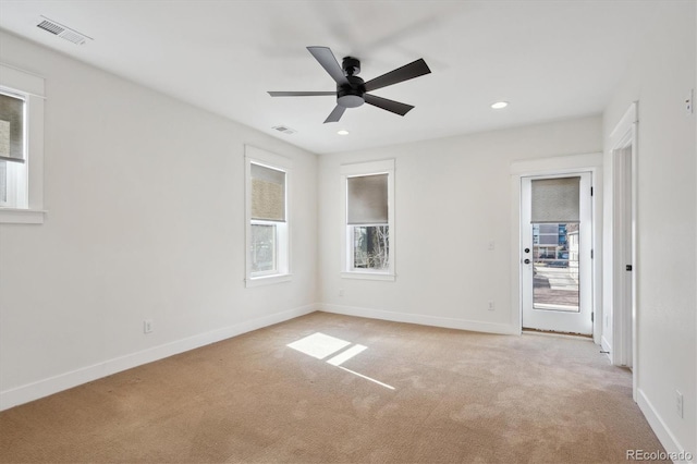 spare room with baseboards, recessed lighting, visible vents, and light colored carpet