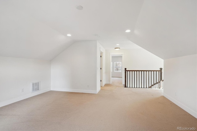 additional living space featuring lofted ceiling, recessed lighting, visible vents, light carpet, and baseboards